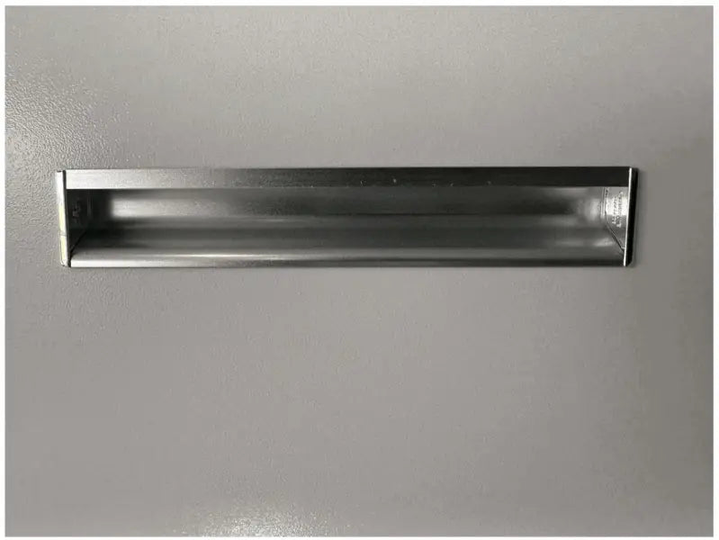 Rectangular metal mail slot installed in a surface.